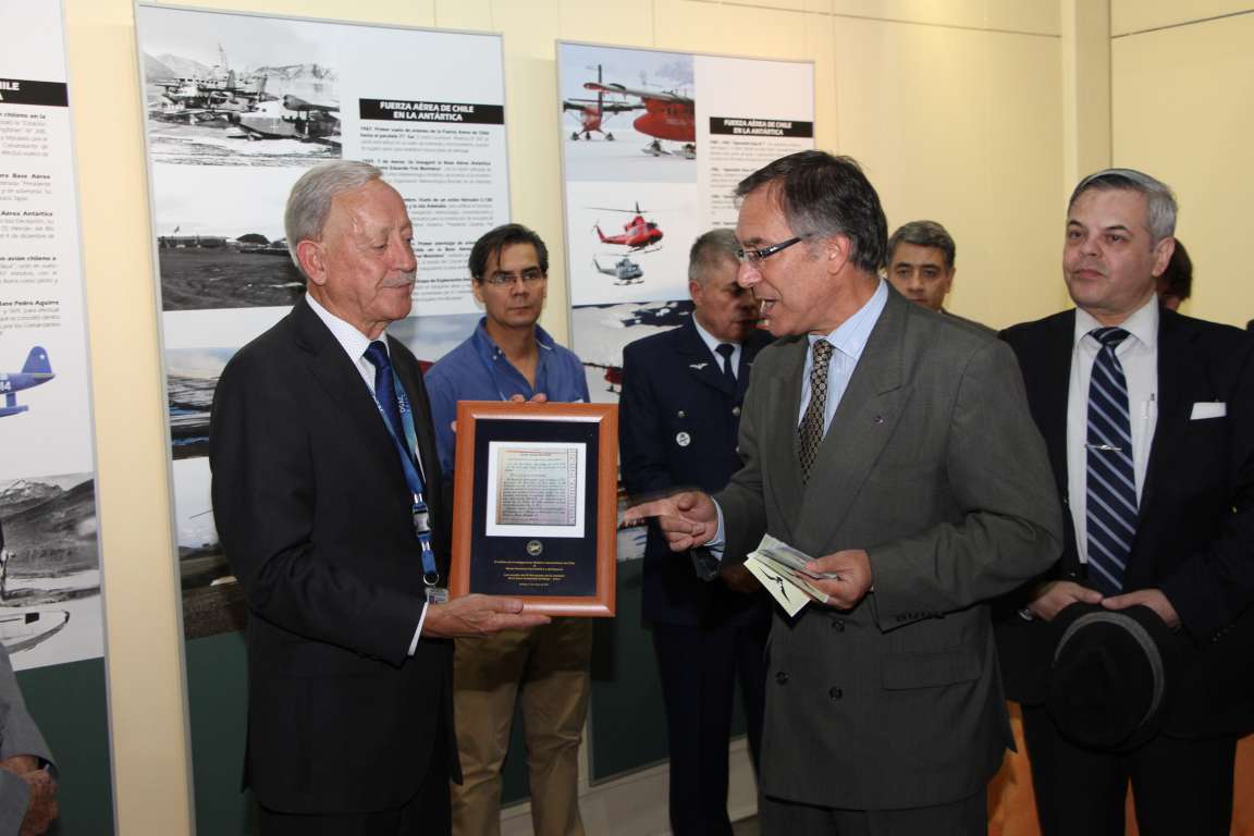 4. Norberto Traub, Presidente del Instituto de Investigaciones Histórico Aeronáuticas de Chile hace entrega de un recorte del Boletín Oficial de Chile.